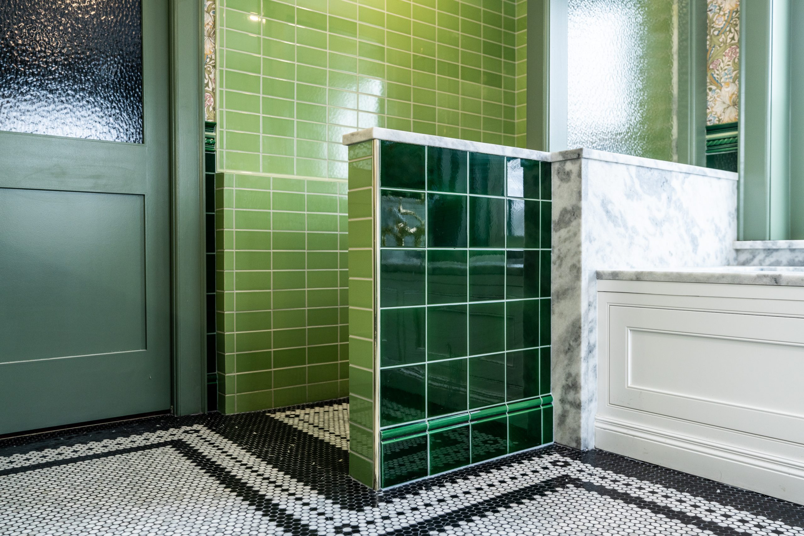 Custom curbless shower with green subway tile and marble penny floor in Waterloo Region bathroom renovation